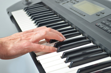 Fototapeta na wymiar Hand playing electronic keyboard