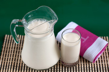 A pitcher of milk and a glass