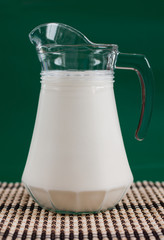 A pitcher of milk and a glass