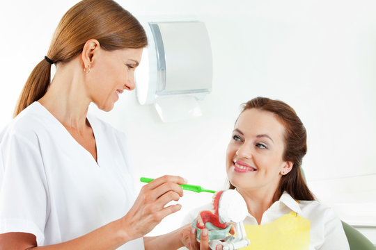 Zahnärztin erklärt Patientin Gebiss