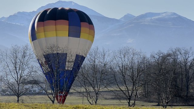 mongolfiera a terra in paesaggio alpino