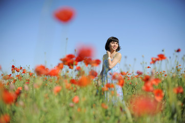 Smiling girl among poppies