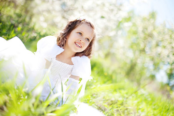 Naklejka na ściany i meble The beautiful little girl, with bush blossoming apple-tree, smil