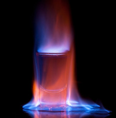 Burning drink in shot glass on a table