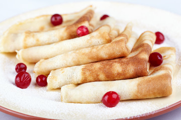 Pancakes with cranberry berries on a white plate