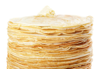 A stack of thin pancakes with butter