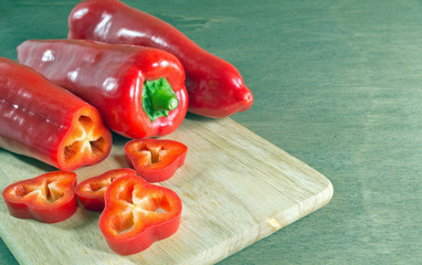 Red paprika peppers sliced on wooden chopping board