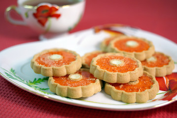 A cup of tea and biscuits on the tablecloth
