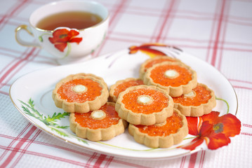 A cup of tea and biscuits on the tablecloth