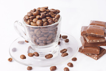 cup with coffee beans pieces of chocolate