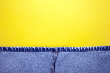 Blue jeans with yellow background