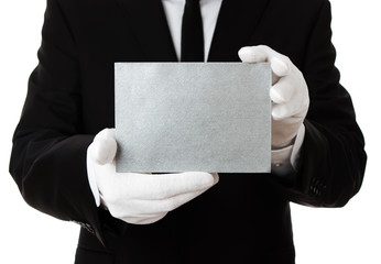 Butler holding blank silver invitation card with copy space