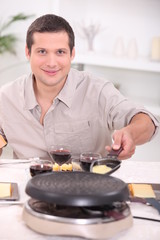 Man cooking raclette at the table