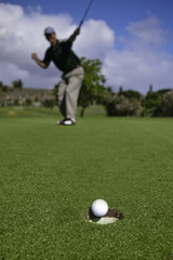 Golfer celebrates sinking a putt