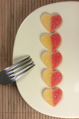 Golosinas, corazones, plato y tenedor.