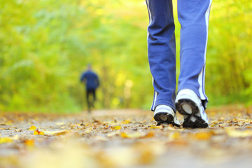 Woman walking cross country trail in autumn forest