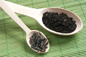 sheet tea in a wooden spoon. As a background the bamboo structur