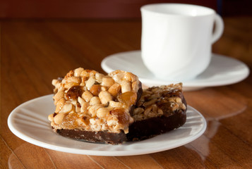 walnut cake on the white plate with a cup of coffee
