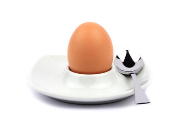 Brown egg in an egg cup with spoon