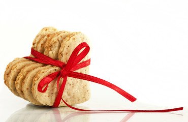 Cookies-hearts connected by a red tape on a white background