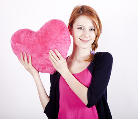Beautiful red-haired girl with toy heart. Photo for st. Valentin