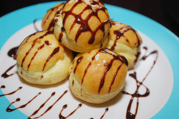 Staff profiteroles with chocolate on the plate.