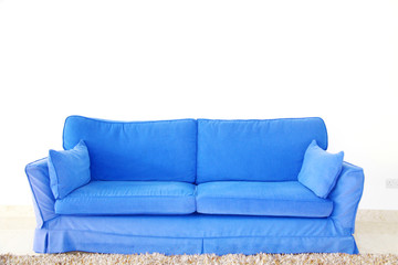 blue double sofa on a blank wall