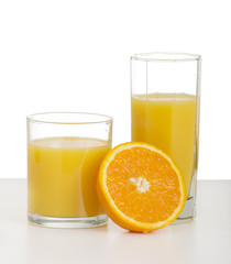 two glasses of orange juice and sliced ripe orange