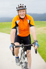 happy active senior man riding bicycle outdoors