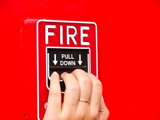 Hand on fire alarm box