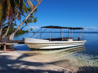 Tropical beach with a boat at dock, Caribbean sea