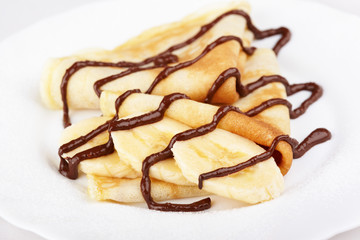 Thin pancakes with banana and chocolate