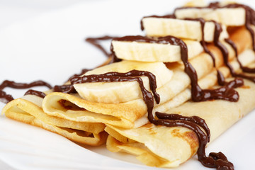 Thin pancakes with banana, ice cream and chocolate