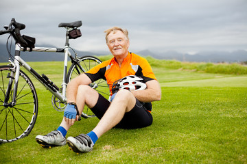 active senior bicyclist taking a break on the hill