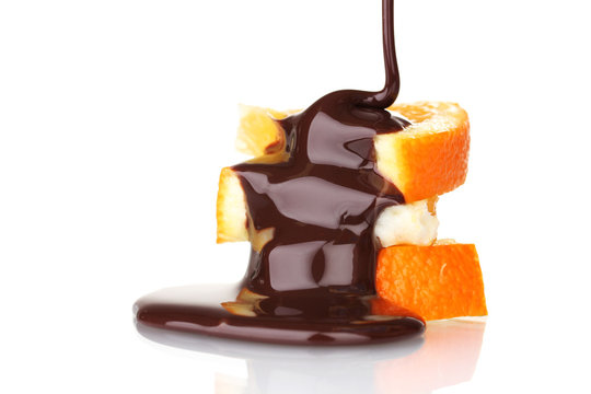 sliced ​​ripe orange with chocolate isolated on white