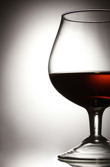 Glass of cognac on grey background