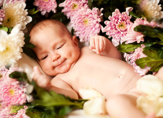Obraz na płótnie Canvas Смеющийся младенец среди цветов