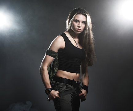 Sexy woman holding daggers with smoke