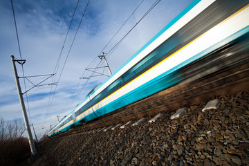 Fast train passing under a bridge on a lovely summer day