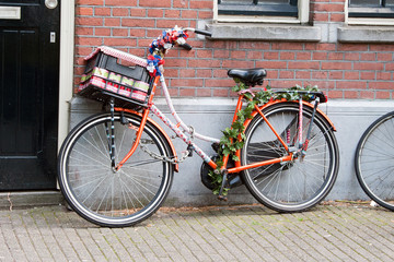 Fototapeta na wymiar Painted bicycle, decorated with artificial flowers