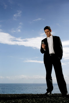 man in coat and tie with mobile phone