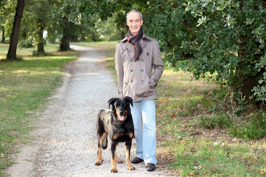 Senior Man Walking His Dog In The Woods