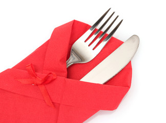 Fork and knife in a red cloth with a bow isolated on white