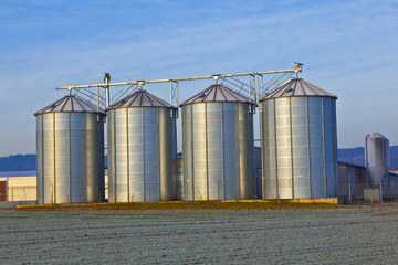 silos in the middle of a field in wintertime