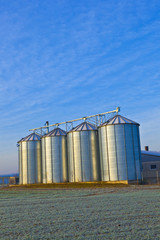 silos in the middle of a field in wintertime