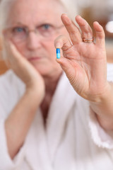 Obraz na płótnie Canvas Elderly woman with a pill
