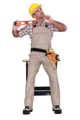 carpenter holding a level and thinking