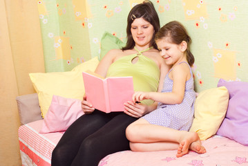 Pregnant mum reads the book of the daughter