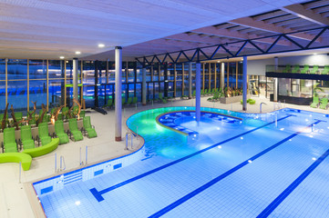 view from the top of a new swimming pool with green divans