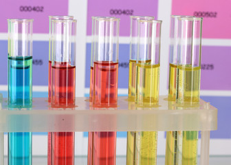 Test-tubes with color liquid on color samples background